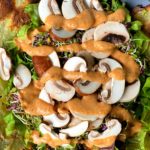 greens and mushrooms covered with a spicy, red tahini sauce